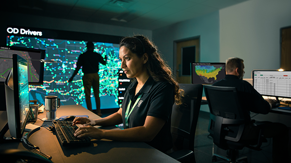 ODFL employee monitoring freight logistics data in a control center with real-time driver tracking.